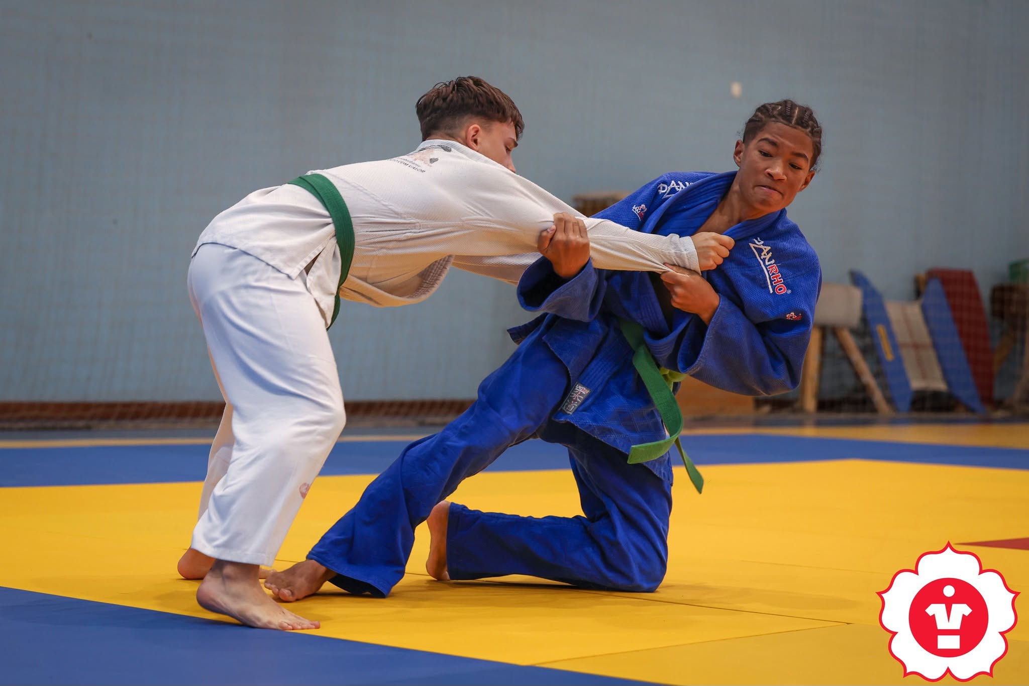 Judocas disputam o combate no tatami.